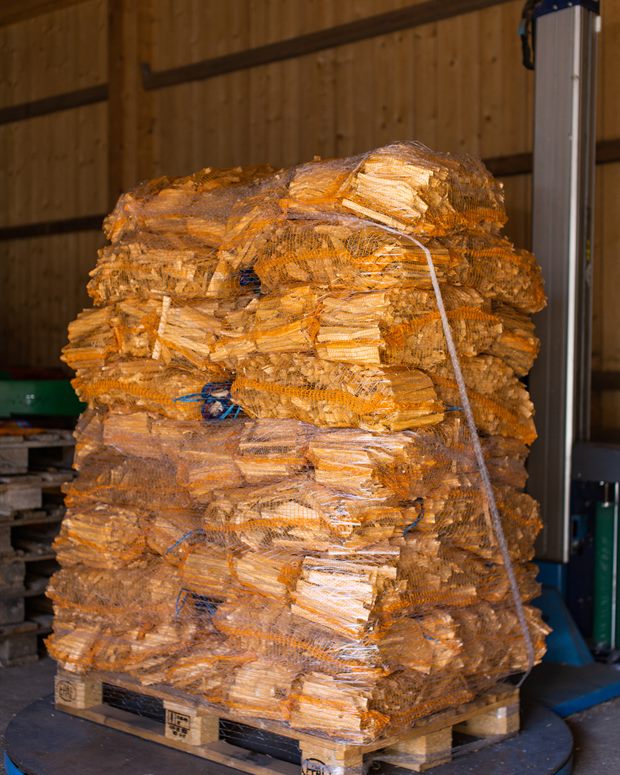 Palette mit Netzsäcken voller Brennholz, bereit zur Auslieferung